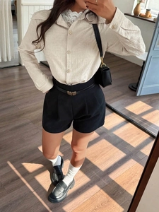 Women's pleated long sleeve beige shirt with vintage buttons and black shorts