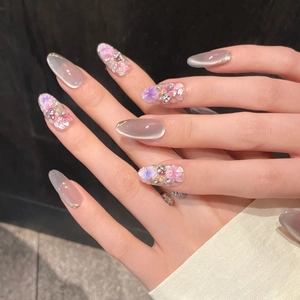 Detail von handgefertigten Cat-Eye-Nägeln mit 3D-Trockenblumen und Glitzerakzenten