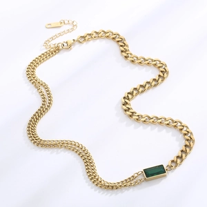 Detail of gold Cuban link chain with rectangular green emerald pendant in stainless steel
