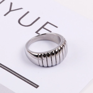 Macro detail of silver stainless steel ring featuring textured vertical croissant stripes