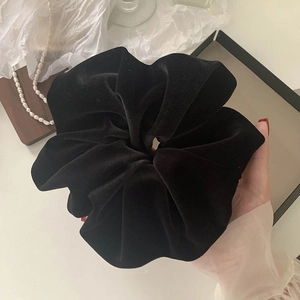 Close-up of oversized black velvet scrunchie showing rich texture and large size