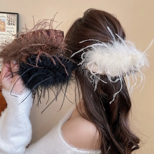 Detail shot of fluffy feather hair claw clips in brown black and cream white colors