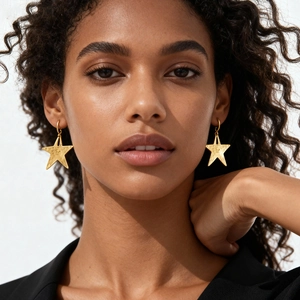Minimalist textured gold star-shaped layered earrings worn by a model for a stylish look