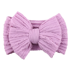 Detailed view of purple knitted nylon baby headband with oversized textured bow