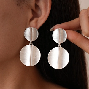 Matte silver geometric double round drop earrings with brushed metal finish on model