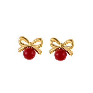 Détail de boucles d'oreilles nœud plaquées or 18 carats avec perles rouges élégantes
