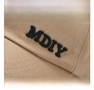 Détail de la casquette de baseball kaki avec broderie MDIY en relief sur tissu de coton