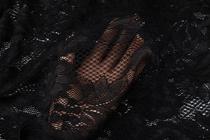 Gros plan sur un tissu en dentelle noire montrant la maille fine et la transparence