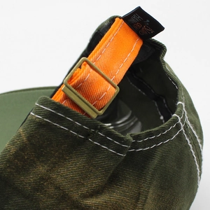 Olive green cotton baseball cap featuring an orange adjustable strap and metal buckle