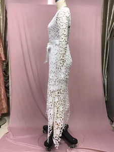 Detail of white lace dress with satin waistband and irregular hollow lace hemline