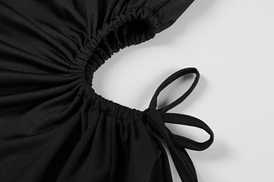 Detailed view of black dress featuring stylish ruching and hollow cut-outs with drawstrings