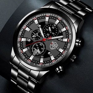 Detail of black stainless steel quartz watch dial featuring luminous hands and date window