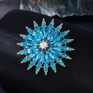 Macro shot of blue crystal snowflake brooch with marquise stones on black fabric
