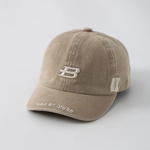 Detailed close-up of khaki cotton baseball cap with 3D white embroidered letter B