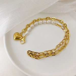 Baroque pearl bracelet with gold heart pendant and 14K chain on white display