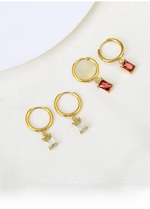Detail of titanium steel earrings with square green and red zircon pendant crystals