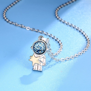 Astronaut couple necklace with blue shimmering helmet and gold star pendant on chain
