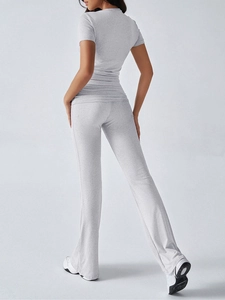 Rear view of model wearing a grey two-piece set with short sleeve top and flared trousers
