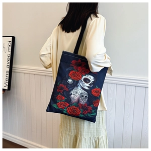 Detail of canvas tote bag with Day of the Dead graphic and rose floral print worn by a model