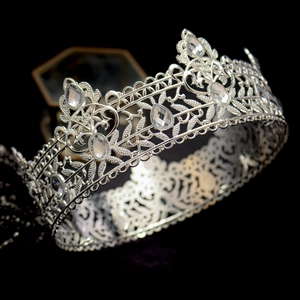 Macro detail of Baroque silver crown featuring intricate leaf patterns and teardrop crystals