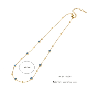 Detail view of a double-layered stainless steel necklace with blue eye charms on white background