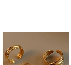 Detail von drei stapelbaren vergoldeten geflochtenen Ringen mit verstellbarem Design