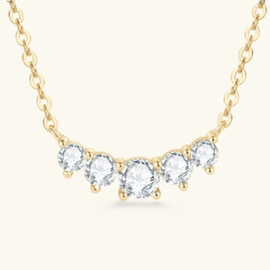 Macro shot of 925 silver gold-plated necklace with five sparkling round-cut stones
