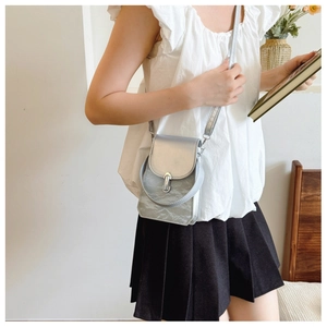Vue détaillée du sac bandoulière argenté avec texture plissée et boucle en métal