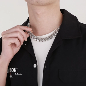 Close-up of men's chunky silver stainless steel Cuban link chain necklace on a model