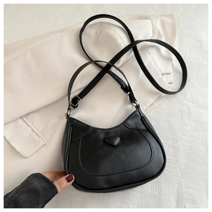 Detail view of matte black hobo bag featuring 3D heart design and fine stitching