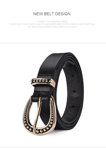 Detail of black leather belt with golden horseshoe buckle and decorative metal beads