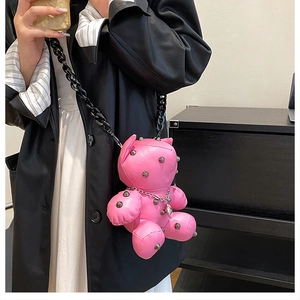 Close-up of pink teddy bear crossbody bag with silver studs and black chain strap