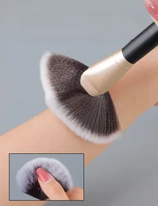 Macro detail of soft black and white gradient fan brush bristles against skin texture