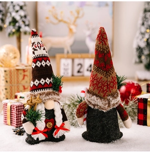 Close-up of Christmas gnome dolls with knitted hats holding ski boards and candy canes