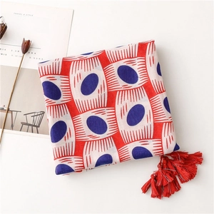 Detailed view of red and blue oval pattern scarf with elegant decorative fringe tassels
