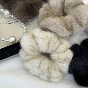 Plush faux fur scrunchies in cream, brown, and black for elegant winter hairstyles