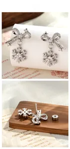 Detailed view of silver bow and snowflake earring with sparkling zircons and screw back