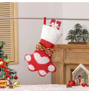 Détail d'une chaussette de Noël en tricot patte de chien avec nœud et boîte cadeau