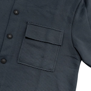 Detail of dark grey twill jacket featuring a chest flap pocket and fine stitching