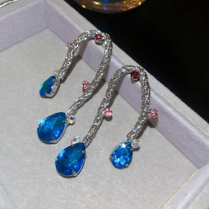 Dettaglio macro di orecchini vintage in argento con cristalli blu a goccia in scatola