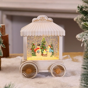 Detailed view of white trolley snow globe with snowmen and swirling golden glitter lights