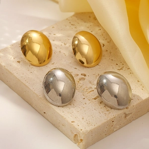 Polished oval stainless steel stud earrings in gold and silver on a stone base