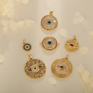 Detailed view of assorted gold plated evil eye charms with multicolor cubic zirconia
