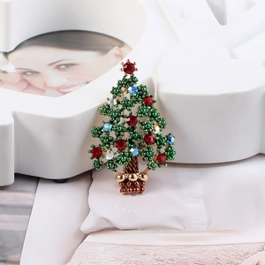 Close-up of a Christmas tree brooch featuring green, red, and blue crystal rhinestones