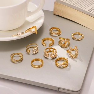 Detailed close-up of 12-piece gold zircon rings set on a laptop surface