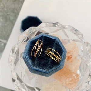 Macro shot of a gold-plated multi-layer twisted ring inside a velvet jewelry box