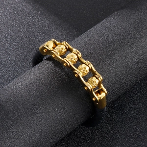 Détails de crânes en métal doré et corde tressée noire sur un bracelet de style motard