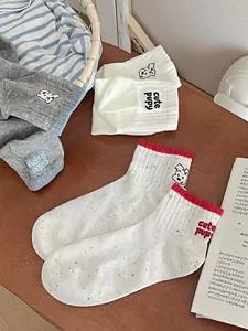 Detail of cotton ankle socks featuring cute puppy embroidery in a rustic basket