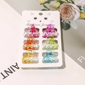 Close-up of 6 colorful transparent mini hair claws on card display for styling hair