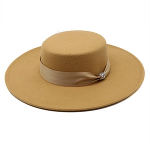 Close-up of khaki wool felt flat top hat featuring satin ribbon and rhinestone buckle